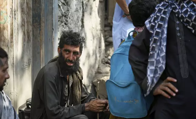Villagers, survivors of Sunday night's 6.0-magnitude earthquake, wait for assistance in the village of Wadir, Kunar province, Afghanistan, Tuesday, Sept. 2, 2025. (AP Photo/Nava Jamshidi)