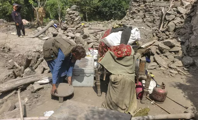 A man collects belongings from the rubble of a collapsed house after a powerful earthquake struck eastern Afghanistan on Sunday, killing many people and destroying villages, in Mazar Dara, Kunar province, Afghanistan, Wednesday, Sept. 3, 2025. (AP Photo/Hedayat Shah)