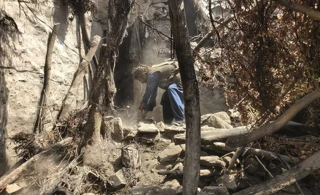 A man tries to clear rubble of a collapsed house after a powerful earthquake struck eastern Afghanistan on Sunday, killing many people and destroying villages, in Mazar Dara, Kunar province, Afghanistan, Wednesday, Sept. 3, 2025. (AP Photo/Hedayat Shah)