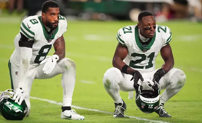New York Jets' Andre Cisco (8) and Brandon Stephens (21) look on as Miami Dolphins' Tyreek Hill is taken off the field after suffering an unknown injury in the second half of an NFL football game, Monday, Sept. 29, 2025, in Miami Gardens, Fla. (AP Photo/Rebecca Blackwell)