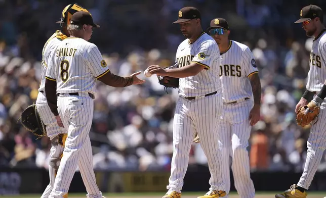 San Diego Padres starting pitcher Nestor Cortes, center, hands the ball to manager Mike Shildt (8) as he exits during the third inning of a baseball game against the Baltimore Orioles Wednesday, Sept. 3, 2025, in San Diego. (AP Photo/Gregory Bull)