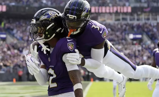 Baltimore Ravens cornerback Nate Wiggins, left, celebrates after an interception with cornerback Chidobe Awuzie during the second half of an NFL football game against the Cleveland Browns, Sunday, Sept. 14, 2025, in Baltimore. (AP Photo/Stephanie Scarbrough)