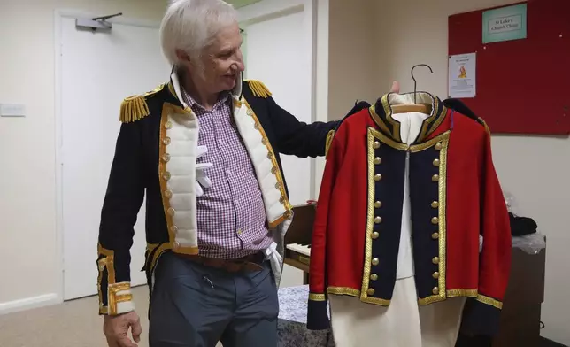 Chris Oswald, chair of the Hampshire Regency Dancers, holds up a period costume he made during a dance practice session of Hampshire Regency Dancers in Winchester, England, Sept. 10, 2025. (AP Photo/Joanna Chan)