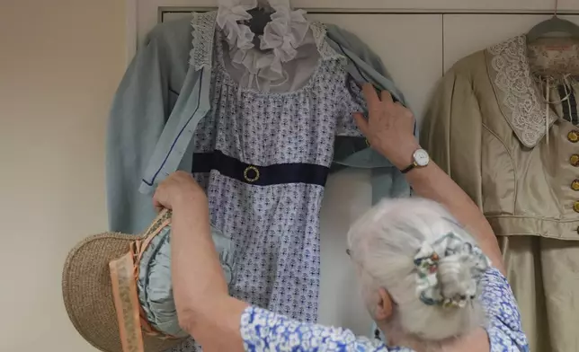 Kate Lobb, a member of the Hampshire Regency Dancers and a tailor, shows a regency-era costume she made during a dance practice session of Hampshire Regency Dancers in Winchester, England, Sept. 10, 2025. (AP Photo/Joanna Chan)