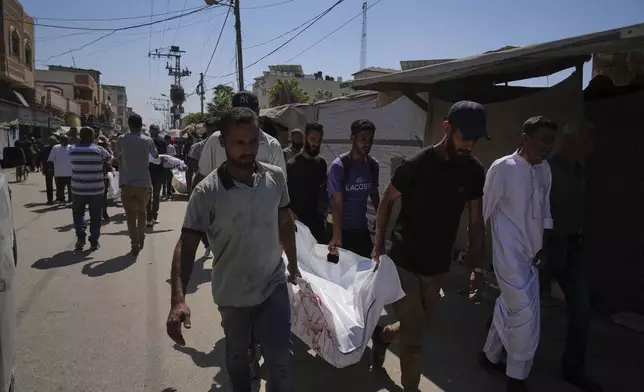 Palestinians carry the body of Aliya Abu Ouda, 37, killed in an Israeli airstrike on the Gaza Strip, in Deir al-Balah, Sunday, Sept. 14, 2025.(AP Photo/Abdel Kareem Hana)
