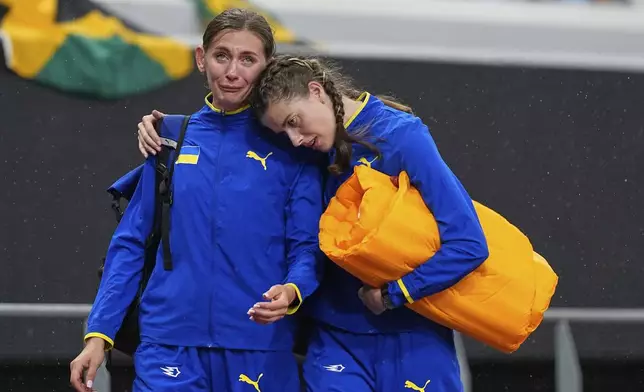 Ukraine's Yaroslava Mahuchikh, right, consoles Ukraine's Kateryna Tabashnyk after the women's high jump qualification at the World Athletics Championships in Tokyo, Thursday, Sept. 18, 2025. (AP Photo/Petr David Josek)