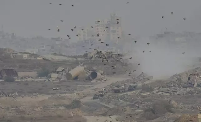 Israeli soldiers drive on their armored personnel carrier inside the northern Gaza Strip, as seen from southern Israel, Sunday, Sept. 21, 2025. (AP Photo/Ohad Zwigenberg)