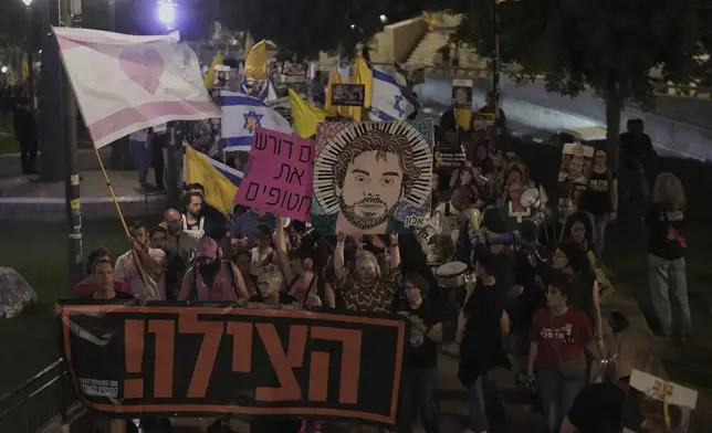 Holding a banner with a message in Hebrew asking for help, relatives and supporters of Israeli hostages held in the Gaza Strip take part in protest demanding their release from Hamas captivity and calling for an end to the war, outside the Old City of Jerusalem, Saturday, Sept. 20, 2025. (AP Photo/Mahmoud Illean)