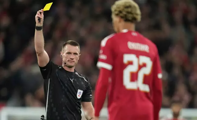 Referee Thomas Bramall shows the yellow card to Liverpool's Hugo Ekitike during the English League Cup third round soccer match between Liverpool and Southampton at the Anfield stadium in Liverpool, England, Tuesday, Sept. 23, 2025. (AP Photo/Jon Super)