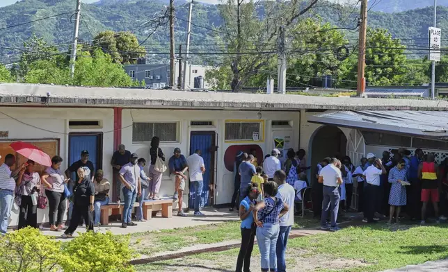 People stand in line to vote at a polling station during general elections in Kingston, Jamaica, Wednesday, Sept. 3, 2025. (AP Photo/Collin Reid)