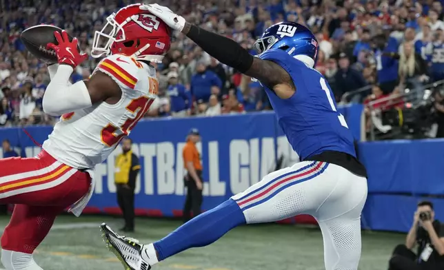 Kansas City Chiefs cornerback Jaylen Watson, left, intercepts a pass intended for New York Giants wide receiver Malik Nabers (1) during the first half of an NFL football game Sunday, Sept. 21, 2025, in East Rutherford, N.J. (AP Photo/Seth Wenig)