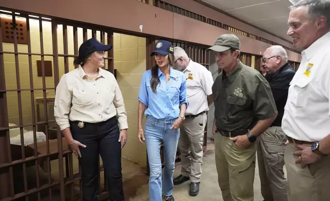 Homeland Security Secretary Kristi Noem, center, tours "Camp 57," a facility to house immigration detainees at the Louisiana State Penitentiary in Angola, La., with Louisiana Gov. Jeff Landry, third left, and ICE Deputy Director Madison Sheahan, left, Sept. 3, 2025. (AP Photo/Gerald Herbert, Pool)