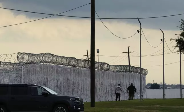 Security walk outside "Camp 57," a facility to house immigration detainees at the Louisiana State Penitentiary in Angola, La., prior to Homeland Security Secretary Kristi Noem touring the facility with Louisiana Gov. Jeff Landry, Attorney General Pam Bondi, and ICE Deputy Director Madison Sheahan, Wednesday, Sept. 3, 2025. (AP Photo/Gerald Herbert)