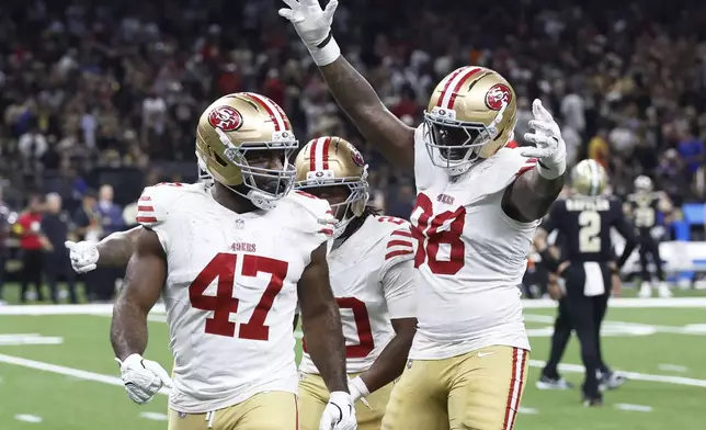 San Francisco 49ers defensive end Bryce Huff (47) celebrates with cornerback Upton Stout, rear, and defensive end Mykel Williams (98) after sacking New Orleans Saints quarterback Spencer Rattler (2) to force a turnover on downs during the second half of an NFL football game in New Orleans, Sunday, Sept. 14, 2025. (AP Photo/Butch Dill)