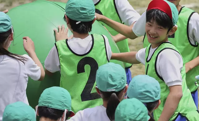 FILE - Japan's Prince Hisahito, right, participates in a sports event at a primary school affiliated with Ochanomizu University in Tokyo, May 19, 2018. (AP Photo/Eugene Hoshiko, Pool, File)