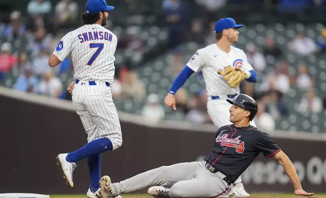 Atlanta Braves' Matt Olson, bottom, slides but is forced out at second by Chicago Cubs shortstop Dansby Swanson (7) during the first inning of a baseball game Wednesday, Sept. 3, 2025, in Chicago. (AP Photo/Erin Hooley)