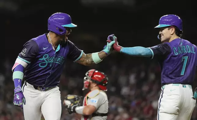 Arizona Diamondbacks' Ketel Marte, left, celebrates his home run against the Philadelphia Phillies with Diamondbacks' Corbin Carroll (7) during the first inning of a baseball game Friday, Sept. 19, 2025, in Phoenix. (AP Photo/Ross D. Franklin)