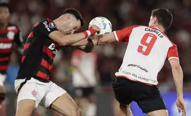 Leo Ortiz of Brazil's Flamengo, left, and Guido Carrillo of Argentina's Estudiantes de La Plata fight for the ball during a Copa Libertadores quarterfinal soccer match at Maracana stadium, in Rio de Janeiro, Thursday, Sept. 18, 2025. (AP Photo/Bruna Prado)