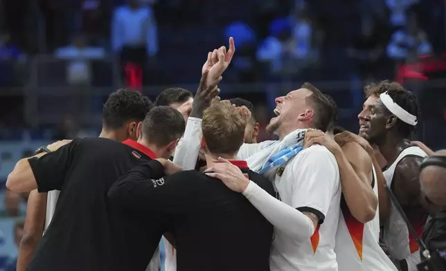 Germany players celebrate after the Eurobasket, European Basketball Championship semi-final match between Germany and Finland at the Riga Arena in Riga, Latvia, Friday, Sept. 12, 2025. (AP Photo/Sergei Grits)