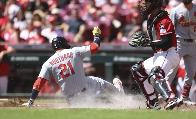 St. Louis Cardinals' Lars Nootbaar (21) slides home on a sacrifice fly by Nolan Gorman in the first inning against the Cincinnati Reds, Sunday, Aug. 31, 2025, in Cincinnati. (AP Photo/Abdoul Sow)