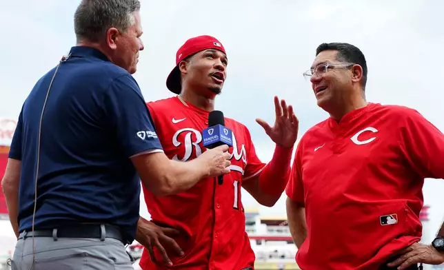 Cincinnati Reds' Noelvi Marte, center, is interviewed following a baseball game against the Pittsburgh Pirates, Thursday, Sept. 25, 2025, in Cincinnati. (AP Photo/Jeff Dean)