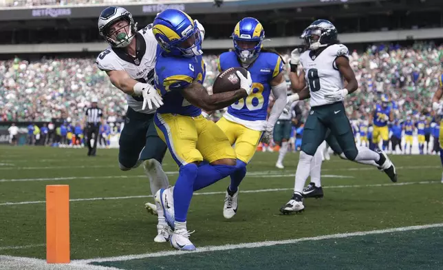 Los Angeles Rams running back Kyren Williams scores past Philadelphia Eagles defensive back Cooper DeJean, left, and cornerback Adoree' Jackson (8) during the second half of an NFL football game Sunday, Sept. 21, 2025, in Philadelphia. (AP Photo/Matt Slocum)