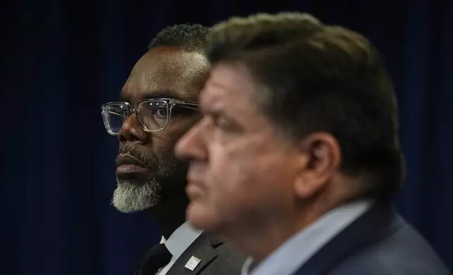 Chicago Mayor Brandon Johnson, background, looks on as Illinois Gov. JB Pritzker, right, speaks during a press conference Tuesday, Sept. 2, 2025, in Chicago. (AP Photo/Kiichiro Sato)