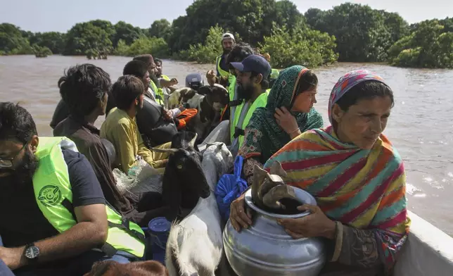 Volunteers evacuate villagers from a flooded area following heavy rains and raising water in rivers, in Muzaffargarh, Pakistan, Thursday, Sept. 4, 2025. (AP Photo/Asim Tanveer)