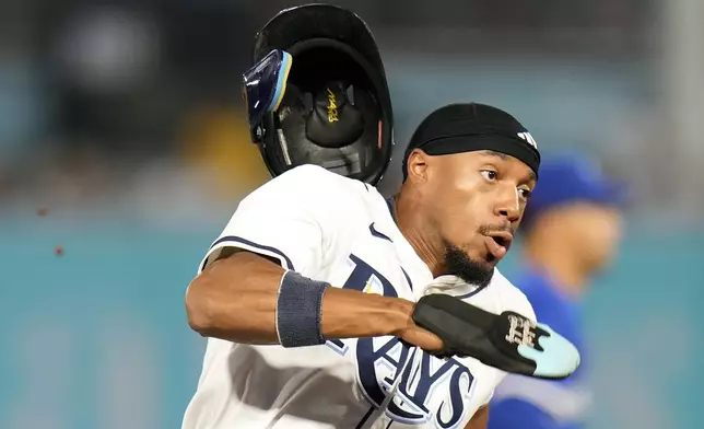 Tampa Bay Rays' Chandler Simpson loses his helmet as he scores on an RBI double by Yandy Díaz off Toronto Blue Jays pitcher Trey Yesavage during the first inning of a baseball game Monday, Sept. 15, 2025, in Tampa, Fla. (AP Photo/Chris O'Meara)