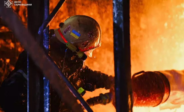 In this photo provided by the Ukrainian Emergency Service, firefighters put out the fire following a Russian drones attack in Kharkiv, Ukraine, Wednesday, Sept. 24, 2025. (Ukrainian Emergency Service via AP)