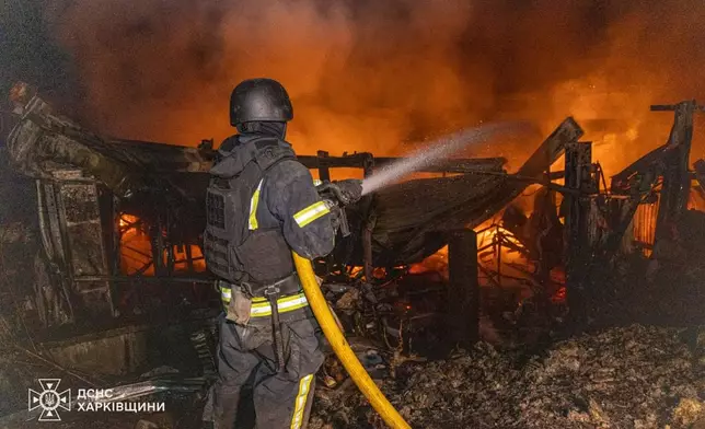 In this photo provided by the Ukrainian Emergency Service, firefighters tries to put out the fire following a Russian drones attack in Kharkiv, Ukraine, Wednesday, Sept. 24, 2025. (Ukrainian Emergency Service via AP)