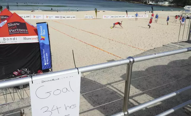 A player falls during a world record attempt for a game of beach touch rugby on Bondi Beach in Sydney, Australia, Thursday, Sept. 4, 2025. (AP Photo/Mark Baker)