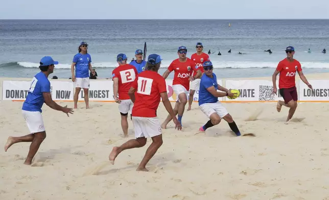 A player runs the ball up during a world record attempt for a game of beach touch rugby on Bondi Beach in Sydney, Australia, Thursday, Sept. 4, 2025. (AP Photo/Mark Baker)