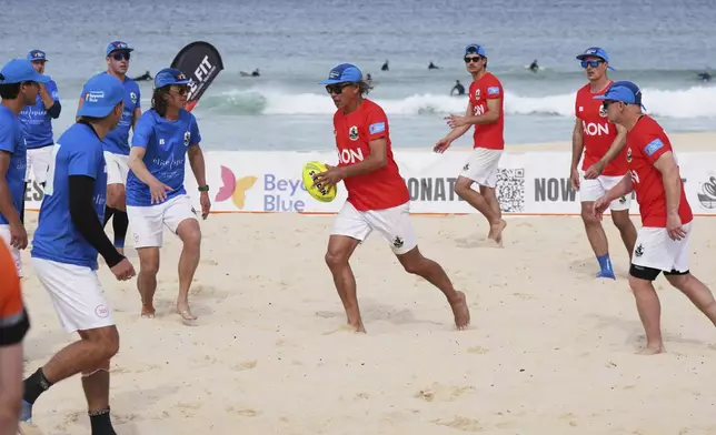 A player runs the ball up during a world record attempt for a game of beach touch rugby on Bondi Beach in Sydney, Australia, Thursday, Sept. 4, 2025. (AP Photo/Mark Baker)