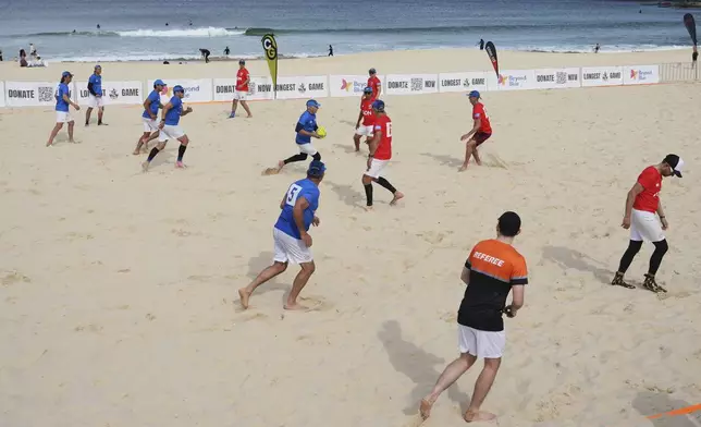 A player runs the ball up during a world record attempt for a game of beach touch rugby on Bondi Beach in Sydney, Australia, Thursday, Sept. 4, 2025. (AP Photo/Mark Baker)