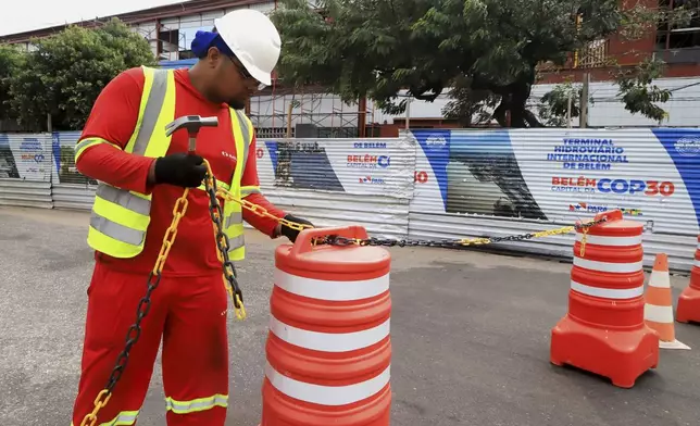 A worker blocks the street to car traffic during construction for the upcoming COP30 U.N. Climate Summit in Belem, Brazil, Sept.18, 2025. (AP Photo/Paulo Santos)