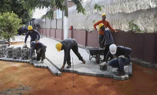 Workers prepare a sidewalk on the banks of the Guajara Bay as part of preparations for upcoming COP30 U.N. Climate Summit, in Belem, Brazil, Sept.18, 2025. (AP Photo/Paulo Santos)