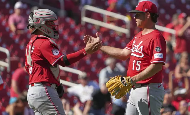 Cincinnati Reds' Emilio Pagan (15) and Jose Trevino celebrate a victory over the St. Louis Cardinals following a baseball game Wednesday, Sept. 17, 2025, in St. Louis. (AP Photo/Jeff Roberson)