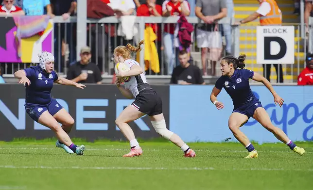 Canada's Paige Farries, center runs with the ball, during the Women's Rugby World Cup 2025 Pool B match between Scotland and Canada, at Sandy Park, in Exeter, England, Saturday, Sept. 6, 2025. (Ben Birchall/PA via AP)