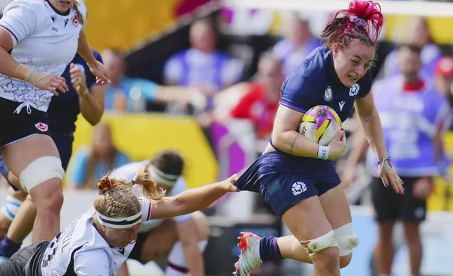 Canada's Courtney O'Donnell, bottom, tries to tackle Scotland's Evie Gallagher, right, during the Women's Rugby World Cup 2025 Pool B match between Scotland and Canada, at Sandy Park, in Exeter, England, Saturday, Sept. 6, 2025. (Ben Birchall/PA via AP)