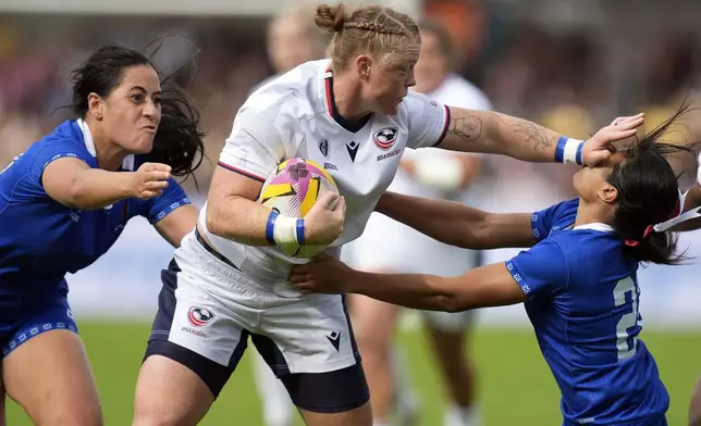 USA's Alev Kelter, center, and Samoa's Faalua Tugaga, right, challenge for the ball during the Women's Rugby World Cup 2025 Pool A match between USA and Samoa in York, England, Saturday, Sept. 6, 2025. (Danny Lawson/PA via AP)