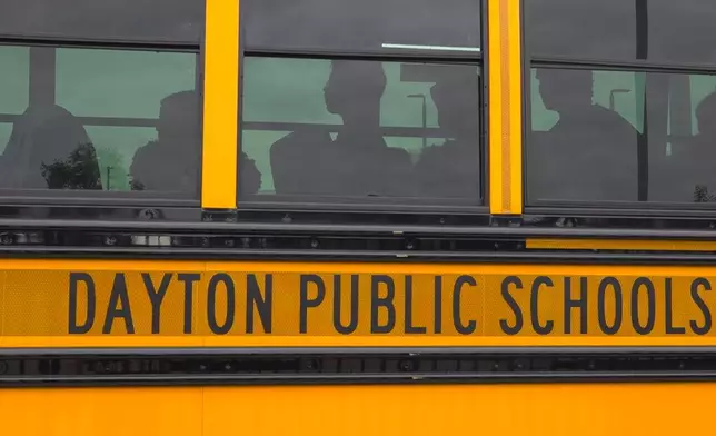 This video taken from photos shows students boarding a school bus on Thursday, August 21, 2025 in Dayton, Ohio. (AP Photo/Patrick Aftoora-Orsagos)