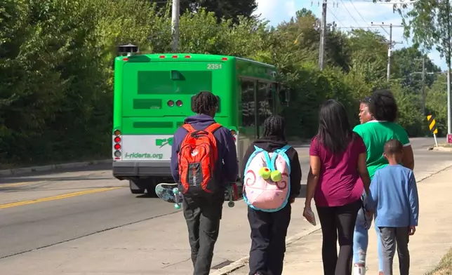 This photo taken from video shows, from left, Kenneth Moore Jr, Suelonnee Tingle, Shonnee Hullum, Sage Harrington and Ronnee Tingle, right front, walking to Ronnee Tingle's car after Moore and Suelonnee Tingle were dropped off by an RTA bus after school Wednesday, September 3, 2025 in Dayton, Ohio. (AP Photo/Patrick Aftoora-Orsagos)