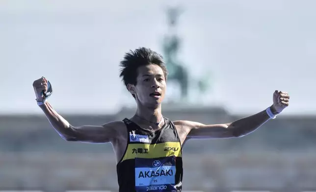 Japan's Akira Akasaki crosses the finish line to finish second in the Berlin Marathon in Berlin, Germany, Sunday, Sept.21, 2025. (AP Photo/Markus Schreiber)