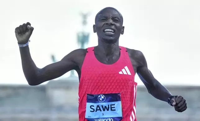 Kenya's Sebastian Sawe crosses the finish line to win the Berlin Marathon in Berlin, Germany, Sunday, Sept.21, 2025. (AP Photo/Markus Schreiber)
