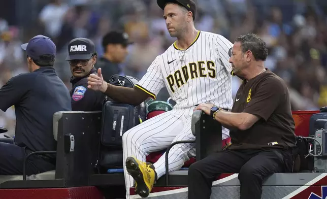 San Diego Padres relief pitcher Jason Adam leaves in a cart after falling with an injury during the seventh inning of a baseball game against the Baltimore Orioles Monday, Sept. 1, 2025, in San Diego. (AP Photo/Gregory Bull)