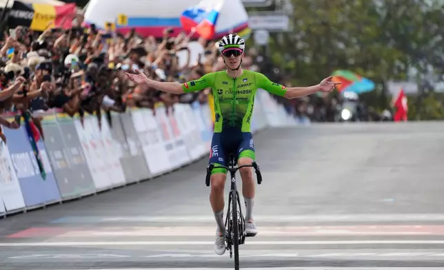 Slovenia's Tadej Pogacar celebrates winning the men's Elite road race, at the road cycling World Championships in Kigali, Rwanda, Sunday, Sept. 28, 2025. (AP Photo/Jerome Delay)