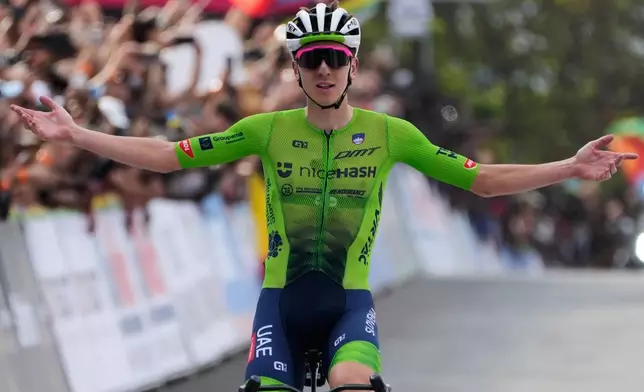 Slovenia's Tadej Pogacar celebrates winning the men's Elite road race, at the road cycling World Championships in Kigali, Rwanda, Sunday, Sept. 28, 2025. (AP Photo/Jerome Delay)