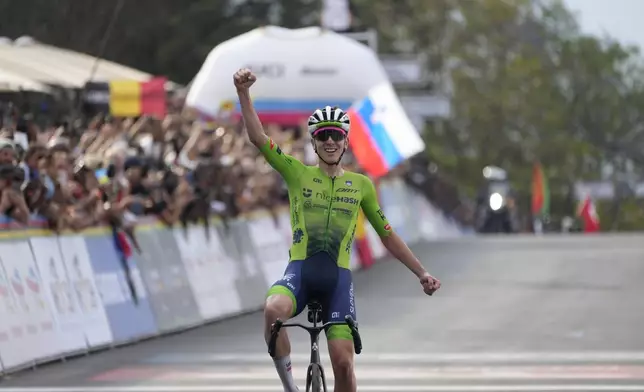 Slovenia's Tadej Pogacar celebrates winning the men's Elite road race, at the road cycling World Championships in Kigali, Rwanda, Sunday, Sept. 28, 2025. (AP Photo/Jerome Delay)