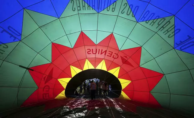 A hot air balloon is partially inflated as it is prepared for a World Ballooning Championships race in Colonia Yguazu, Paraguay, Friday, Aug. 29, 2025. (AP Photo/Jorge Saenz)